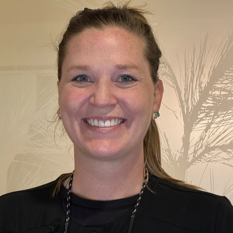 Smiling woman wearing black shirt in dental office interior setting